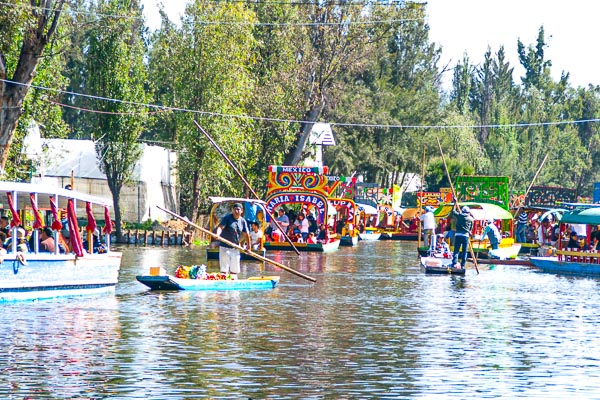 Several colorful boats navigating thru the Chanels of Xochimilco, Mexico